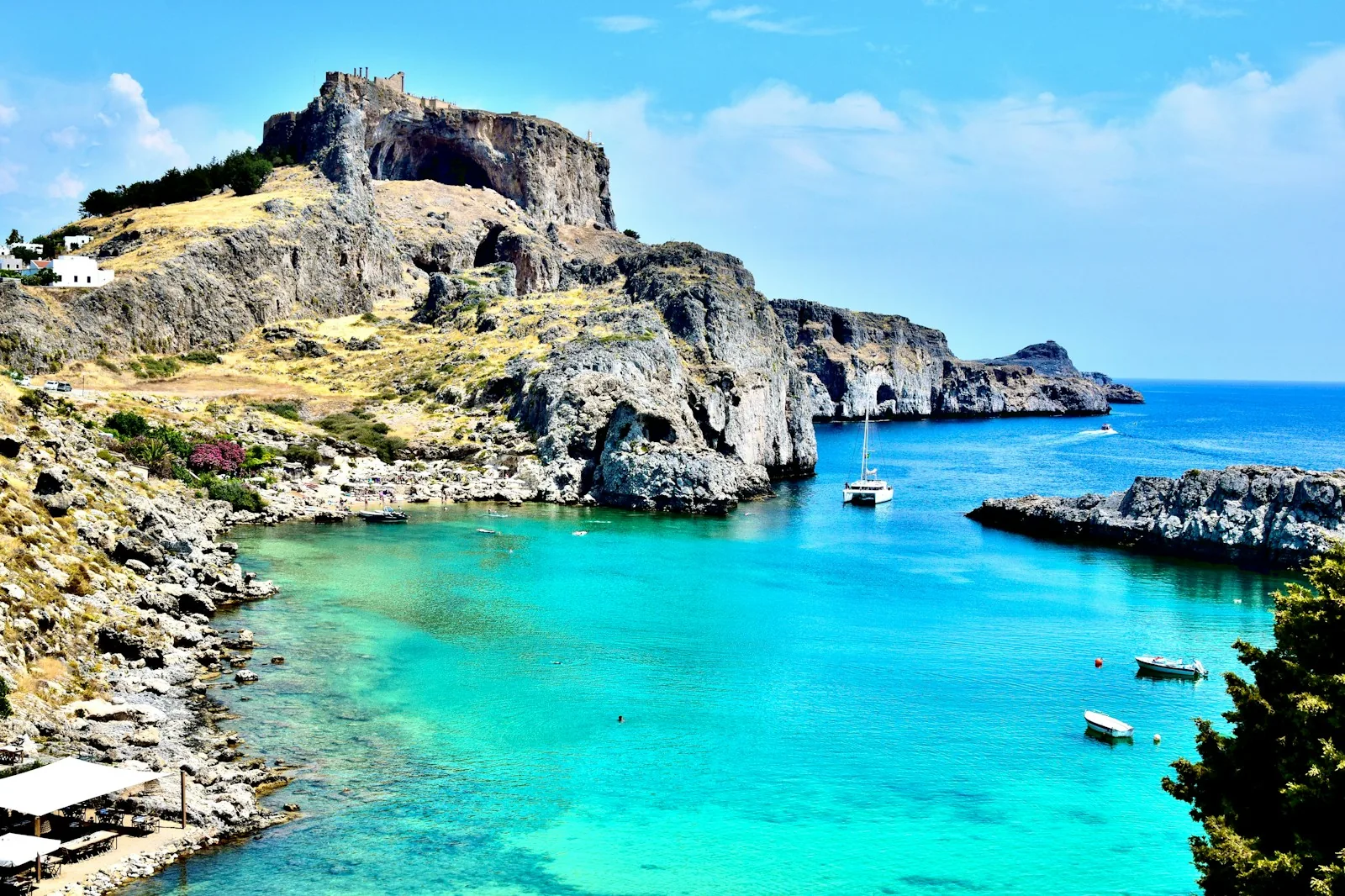 Türkisfarbene Bucht von Lindos auf Rhodos mit Felsen und Akropolis