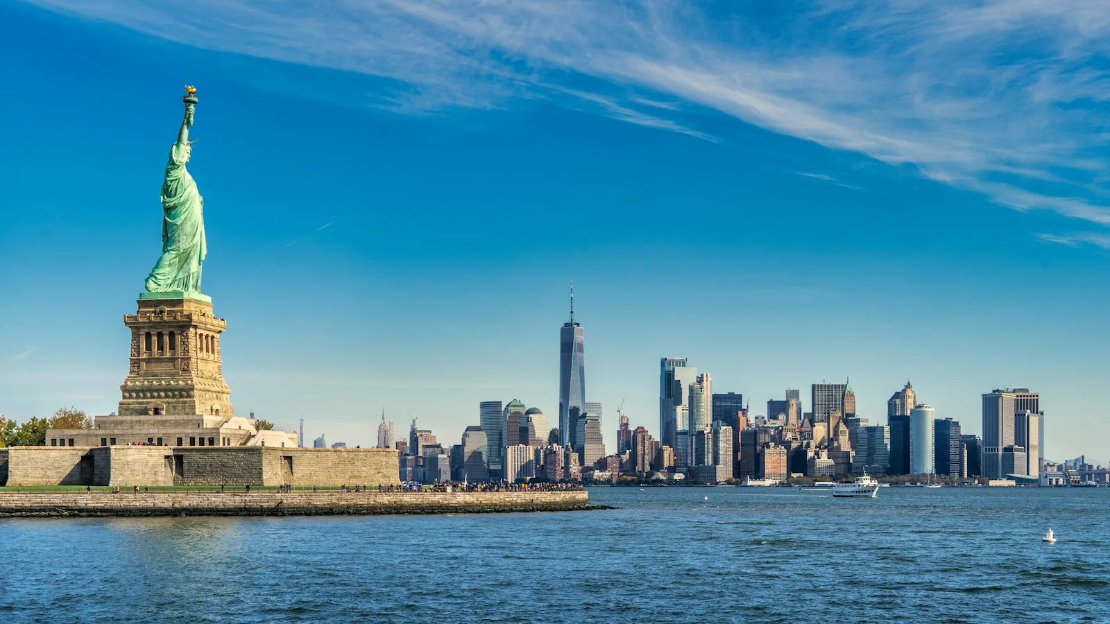 Freiheitsstatue auf Liberty Island vor der Skyline von Manhattan