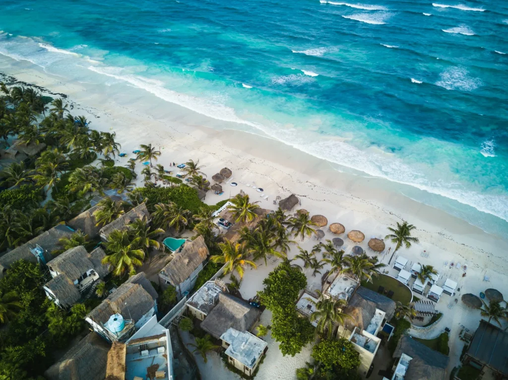 Karibikstrand mit Palmen und Hotelanlagen an der Riviera Maya aus der Luft