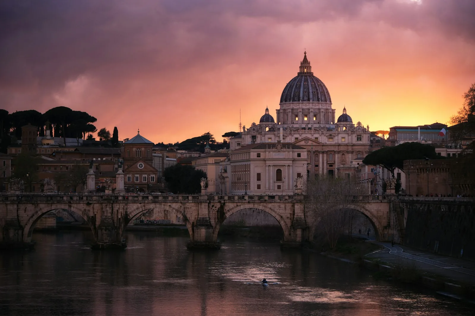 Kuppel des Petersdoms über dem Tiber in Rom bei Sonnenuntergang