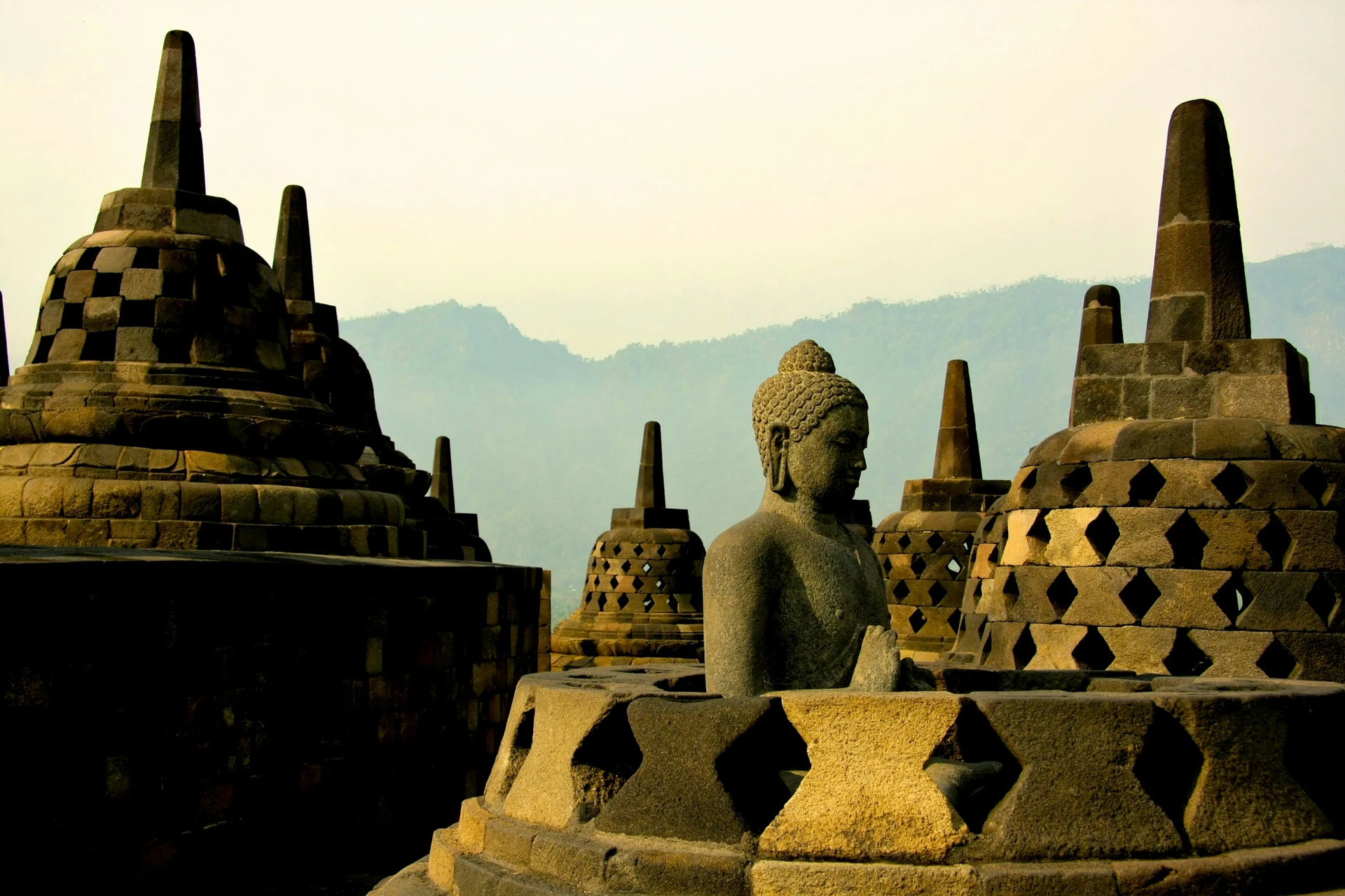 Buddha-Statue zwischen glockenförmigen Stupas im Tempel Borobudur auf Java
