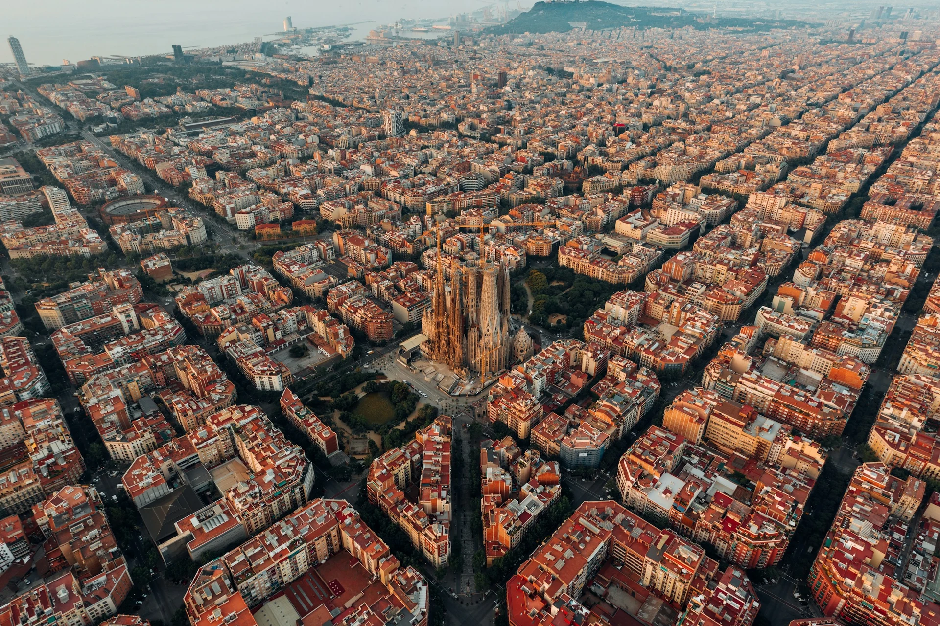 Die Sagrada Família inmitten des Schachbrettmusters des Eixample in Barcelona aus der Luft