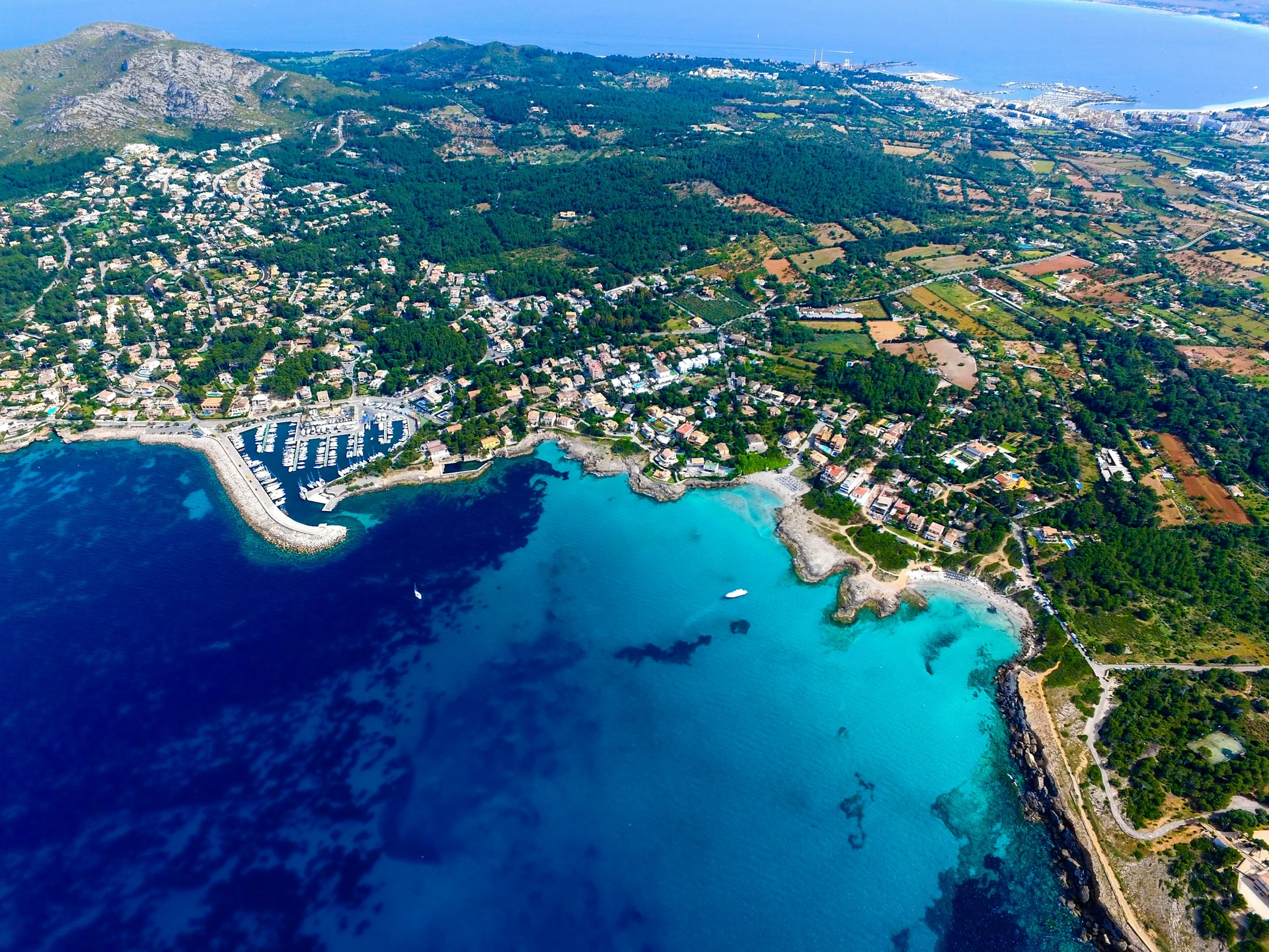 Türkise Bucht und bewachsene Küste auf Mallorca aus der Luft