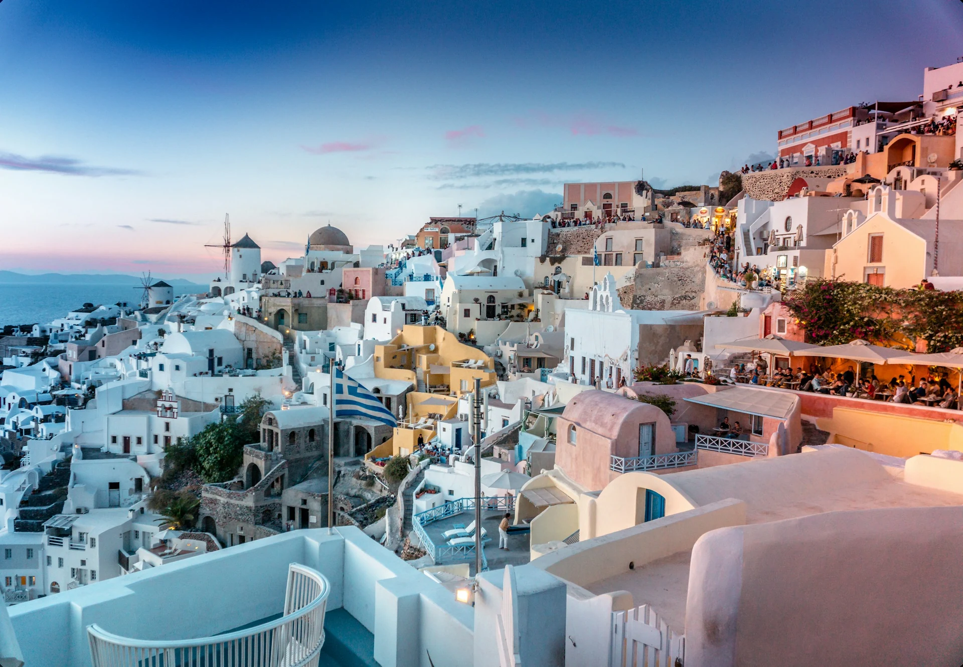 Weiße Häuser und blaue Kuppeln von Oia am Kraterrand von Santorini